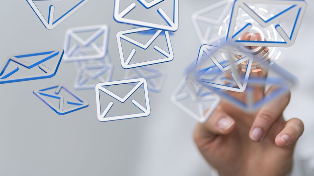 3D email icons floating and a person's hand pressing on one of them.