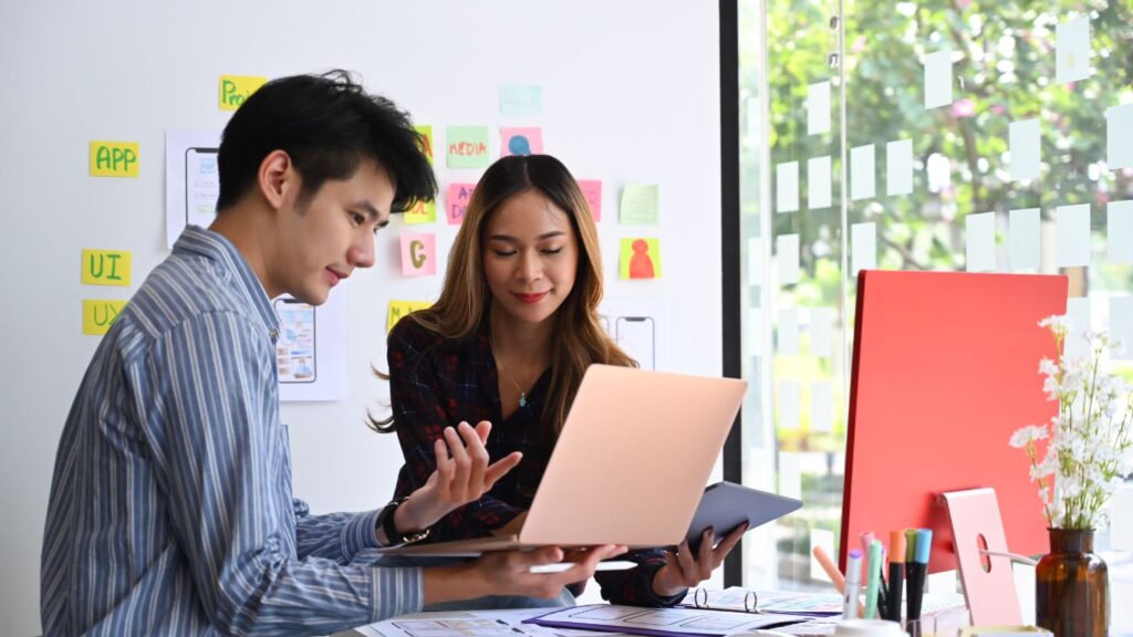 Man and woman looking over a laptop