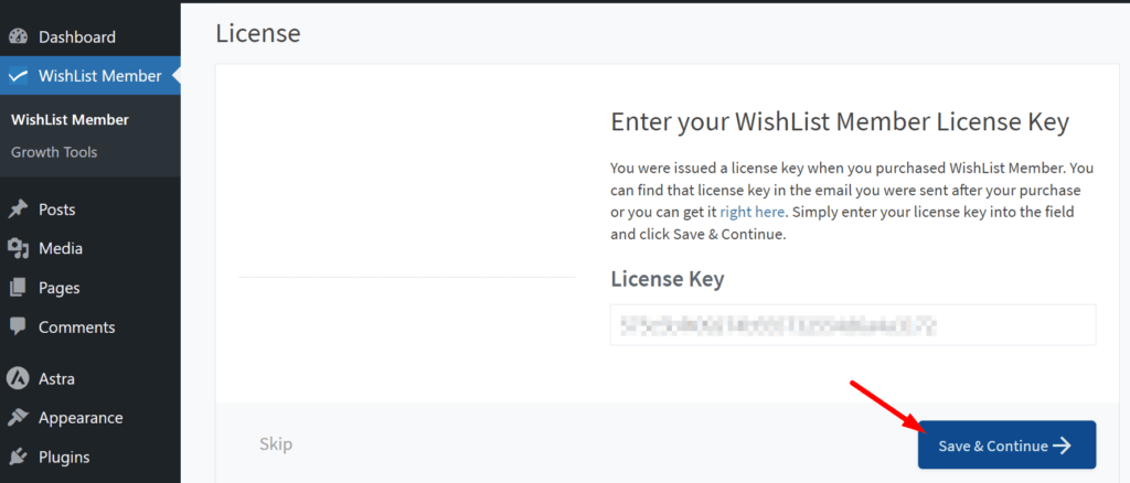 Screenshot of the WishList Member plugin page on WordPress, with a prompt to 'Enter your WishList Member License Key.' The license key field is displayed with an obscured key, and an arrow points to the 'Save & Continue' button, indicating the next step in activating the plugin.